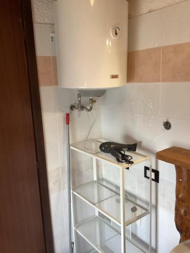 a kitchen with a shelf with a hair dryer at Casa Scarbini in Savogna