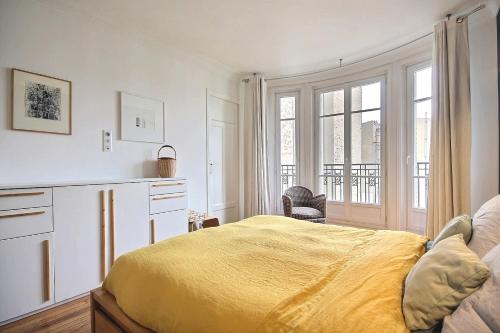 une chambre avec un lit jaune et une fenêtre dans l'établissement Gambetta family pad, à Paris