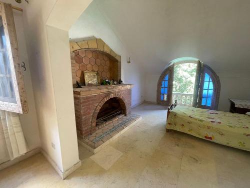 a living room with a brick fireplace and a bed at فيلا عائلات فقط Families only - سيدى كرير Sidi Krir - خارج القرى السياحية Outside tourist villages- حديقة خاصة مستقله ومسبح خاص مشترك Private Garden-Shared Pool in Abû Zeira