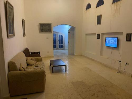 an empty living room with a couch and a tv at فيلا عائلات فقط Families only - سيدى كرير Sidi Krir - خارج القرى السياحية Outside tourist villages- حديقة خاصة مستقله ومسبح خاص مشترك Private Garden-Shared Pool in Abû Zeira