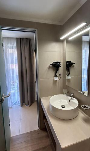a bathroom with a white sink and a mirror at Elite Centre in Rhodes Town