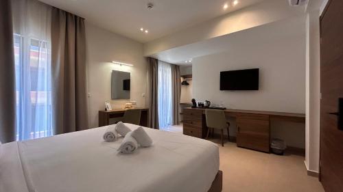 a hotel room with a bed and a desk and a television at Elite Centre in Rhodes Town