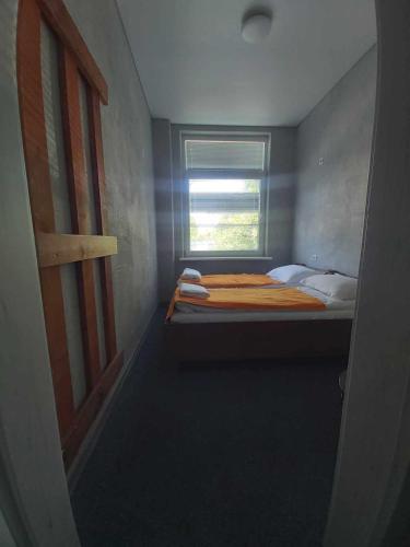 a small bedroom with a bed and a window at Estrella Palanga Home in Palanga