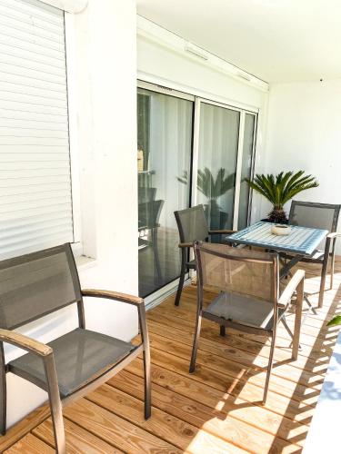 a patio with a table and chairs on a balcony at T3 Moderne avec balcon terrasse et parking gratuit in Niort