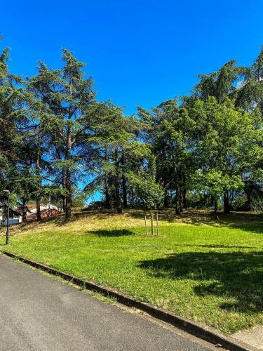a field of grass with trees on the side of a road at T3 Moderne avec balcon terrasse et parking gratuit in Niort