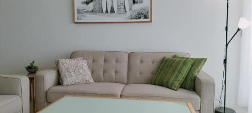 a living room with a couch and a table at Darwin Harbour Suites in Darwin