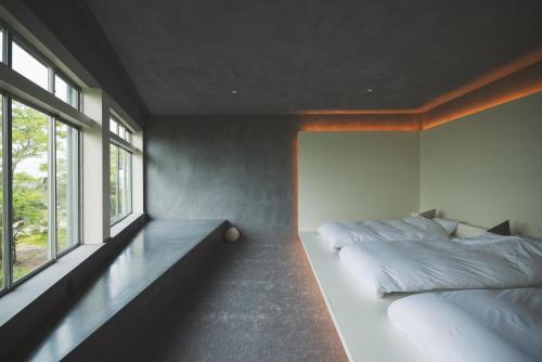 a bedroom with two beds and a large window at 清風荘 in Kosai