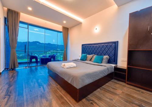 a bedroom with a large bed with a large window at Kodai Outdoor Valley in Kodaikānāl