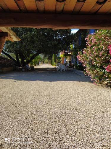 a view of a road with a tree and flowers at La maison de Nazig in Pertuis