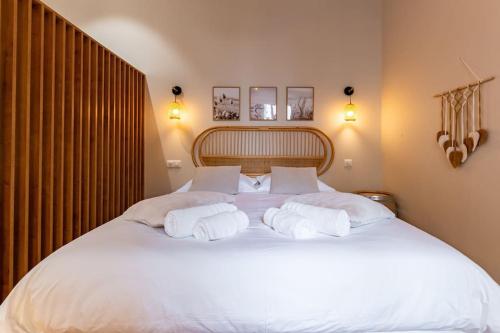 une chambre avec un grand lit blanc avec deux oreillers dans l'établissement Le Volnay, à Dijon