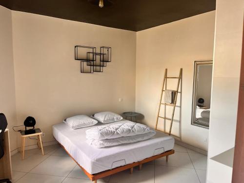 アンデルノ・レ・バンにあるvilla patio proche centre villeのベッドルーム1室(白いシーツとシャンデリア付)