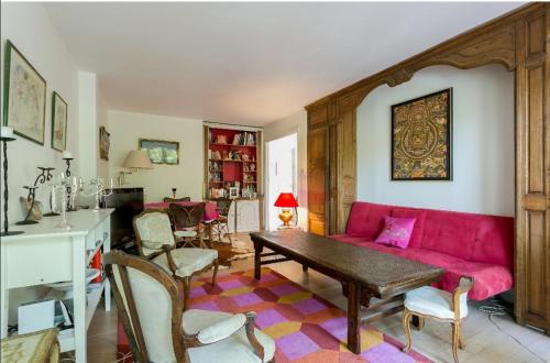 un salon avec un canapé rouge et une table dans l'établissement A 30mn des Jeux Olympiques lumineux 3 pièces face à la seine à 100m du T2, à Saint-Cloud