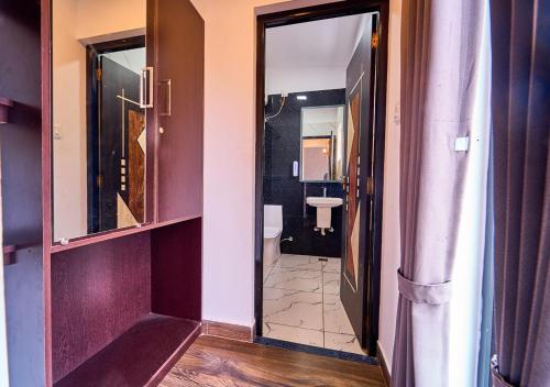 a hallway of a bathroom with a toilet and a mirror at Kodai Outdoor Valley in Kodaikānāl