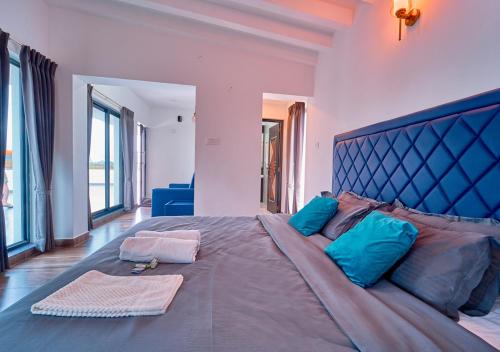a large bed with blue pillows in a bedroom at Kodai Outdoor Valley in Kodaikānāl