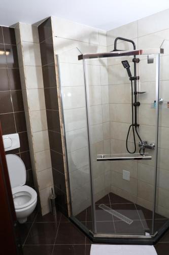 a bathroom with a shower and a toilet at Bruti Hotel in Prizren