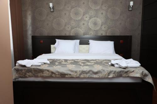 a bedroom with a bed with two towels on it at Bruti Hotel in Prizren