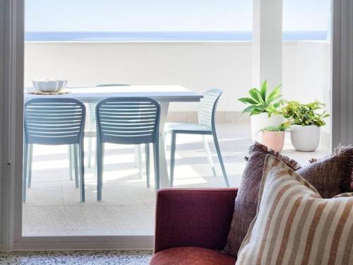 a living room with a table and chairs and a couch at Santorini on Sands, a Sellicks Beach paradise in Sellicks Beach
