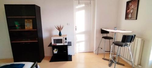 - un salon avec un four micro-ondes et une table dans l'établissement Location chambre spacieuse avec balcon et piscine, à Albi