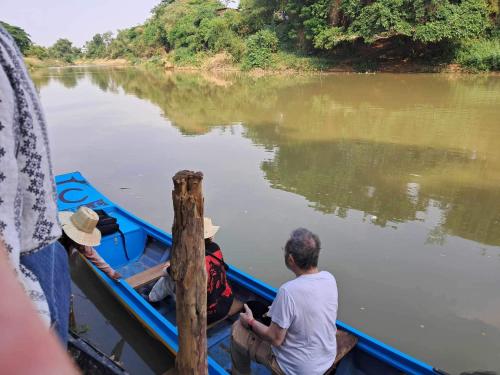 a group of people sitting in a boat on a river at La maison bleue BTB in Phumĭ Kâmpóng Âmpĭl
