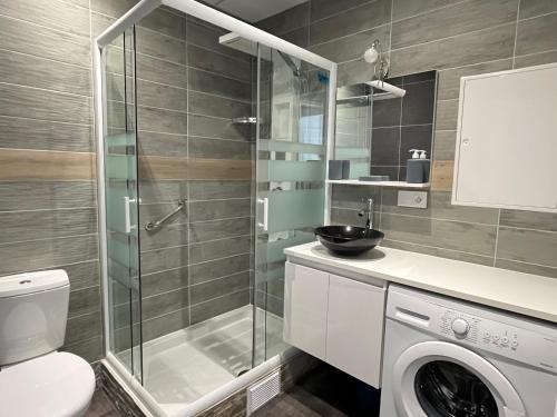 La salle de bains est pourvue d'un lave-linge et d'une douche. dans l'établissement Résidence Harmony, à Vichy