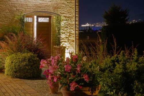 阿西西Agriturismo - La Campagna di San Francesco的砖砌建筑前种满鲜花的花园