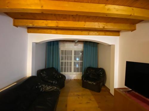 a living room with two black leather couches at Cabanita in Întorsura Buzăului