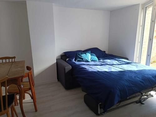 - une chambre avec un lit doté d'une couette bleue et d'une table dans l'établissement Beau studio à 2mn de la mer et avec jardin, à Bray-Dunes