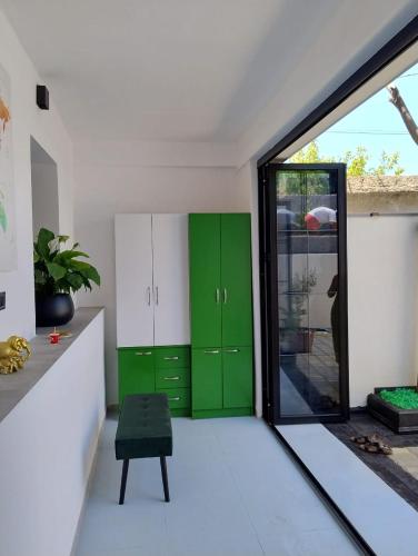 a room with green cabinets and a green chair at Vila Kurti in Vlorë