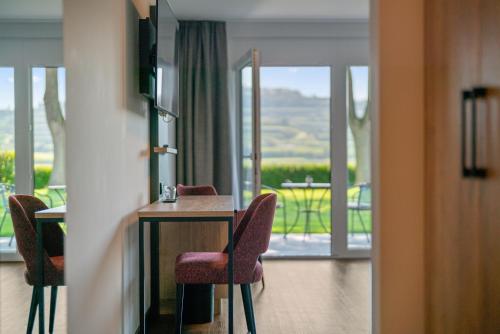 a room with a table and chairs and a balcony at Köpfers Steinbuck in Bischoffingen