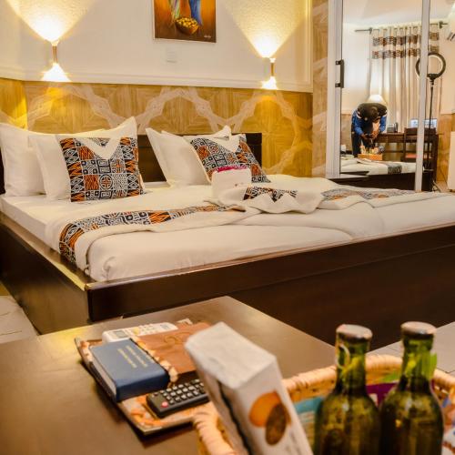 ein Hotelzimmer mit einem Bett und einem Tisch mit Flaschen in der Unterkunft La Vallée de Bana in Bana