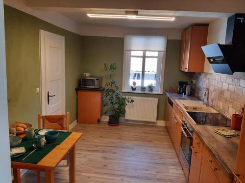 eine Küche mit Tisch und Arbeitsplatte in der Unterkunft Gäste- und Monteurwohnung alte Gärtnerei in Kalefeld