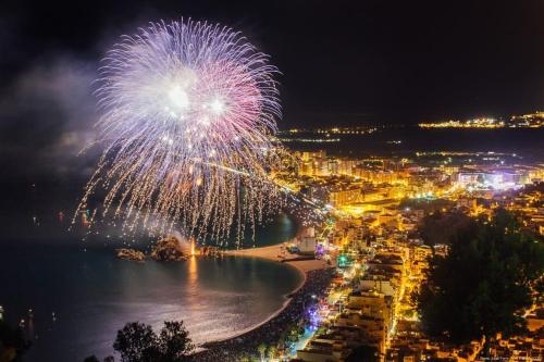 a firework display over a beach at night at Habitación Sa Palomera con baño privado a 2 min del mar in Blanes