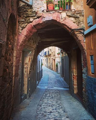 an alley way with an archway in an old building at La Caseta del Piro in Gratallops