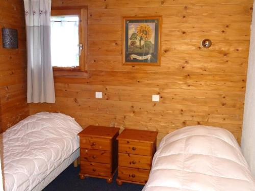 deux lits dans une chambre aux murs en bois dans l'établissement Les Gets : Appartement 6 pièces, 13 pers, Wi-Fi, 200m commerces, 450m pistes, draps et serviettes inclus - FR-1-802-55, aux Gets