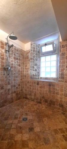 La grande salle de bains est pourvue d'une douche et d'une fenêtre. dans l'établissement Vue Cité-Centre Historique-Patio-Tendance-calme, à Carcassonne