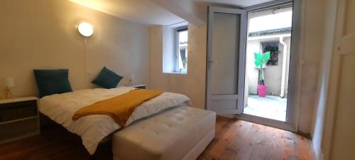 une chambre avec un lit et une grande fenêtre dans l'établissement Vue Cité-Centre Historique-Patio-Tendance-calme, à Carcassonne