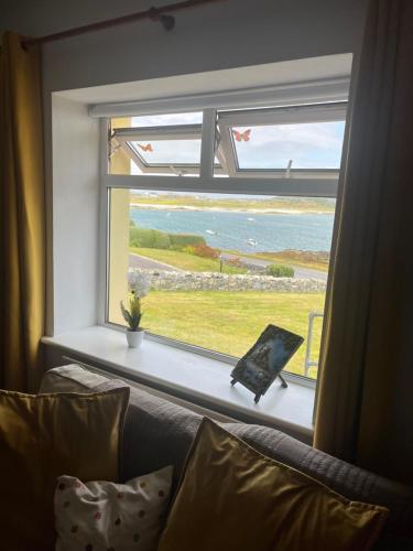 a window in a living room with a view of the ocean at Pier view house in Ballyconneely