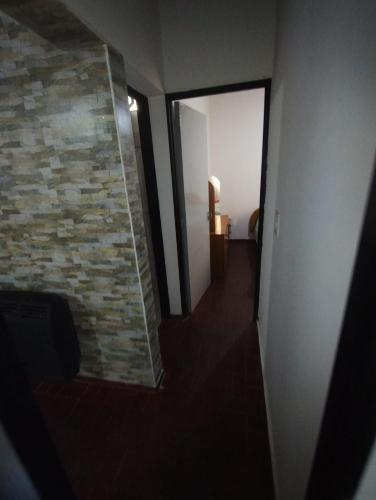 a room with a hallway with a stone wall at Alojamiento MyC in Malargüe