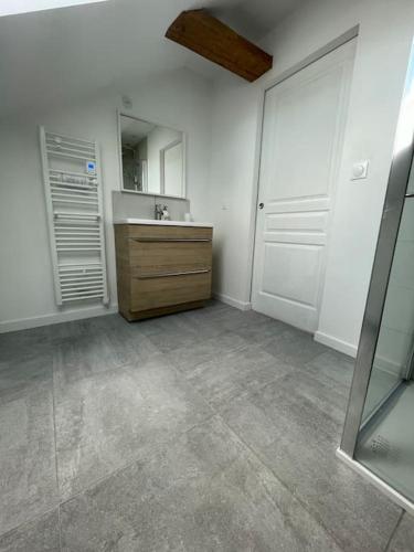 une salle de bains vide avec lavabo et miroir dans l'établissement Confort & calme en famille - proche Omaha Beach & Bayeux - jusqu'à 6 pers, à Trévières