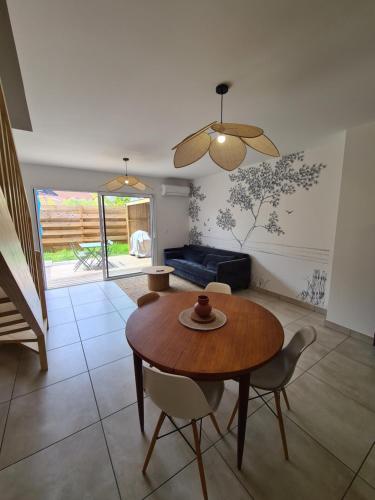 un salon avec une table et des chaises en bois dans l'établissement Maison Marsane côte Landaise, à Lit-et-Mixe
