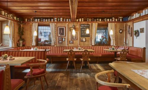 a restaurant with wooden walls and tables and chairs at Aktivhotel & Gasthof Schmelz Ihr familienfreundliches Urlaubs Hotel mit Wellness Hallenbad, Alpensauna neu ab Februar 2026 Chiemgau Karte in Inzell