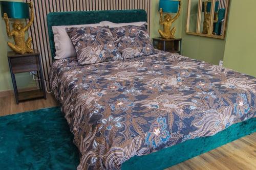 Una cama en un dormitorio con dos mesitas de noche y dos estatuas. en Coin de nature en centre-ville, en Troyes