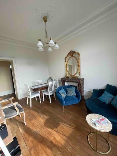 un salon avec un canapé bleu et une table dans l'établissement La Vie Dijonnaise, à Dijon