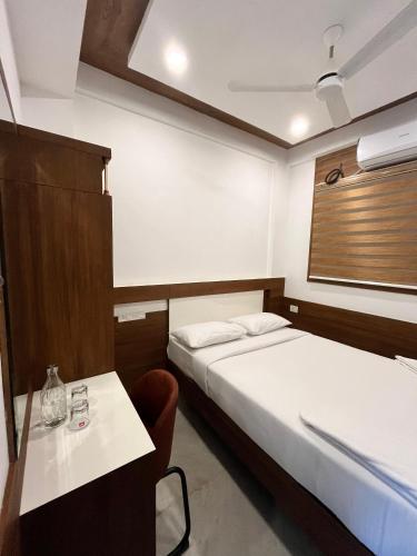 a hotel room with two beds and a table at Welcome Hotels in Trichūr