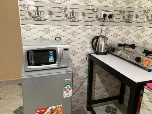 a kitchen with a microwave on top of a refrigerator at Rembeka furnished apartments in Naivasha