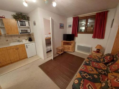 un salon avec un canapé et une cuisine dans l'établissement Studio Mount La Vie, à Allos