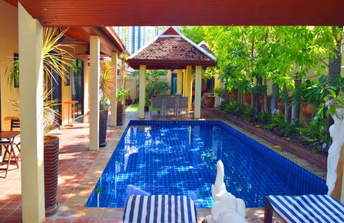 a swimming pool with two chairs and a gazebo at 4 Bed Villa Private Pool and BBQ Jomtien Beach in Jomtien Beach