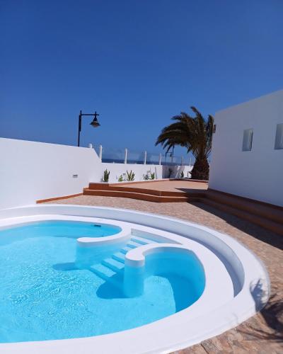 a swimming pool in the backyard of a house at Blue Miracle Villa in Arrecife