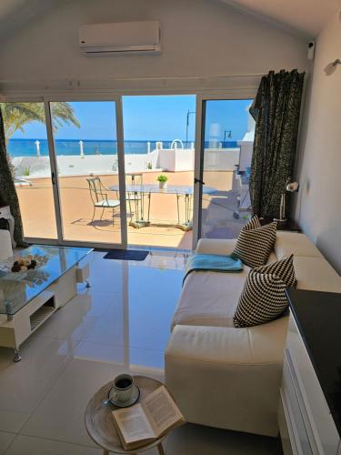 a living room with a couch and a view of the beach at Blue Miracle Villa in Arrecife