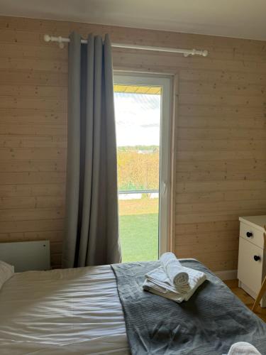 a bedroom with a bed and a large window at Jaśminowy Sad in Mikołajki